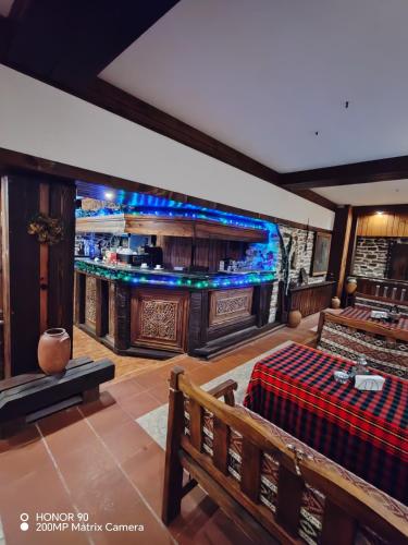 a room with a bar with a bench and a table at Парк - Хотел Макензен in Melnik
