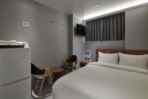 ソウルにあるEight Rest Hostel Jong-roのベッドルーム1室(ベッド1台、テーブル、椅子付)
