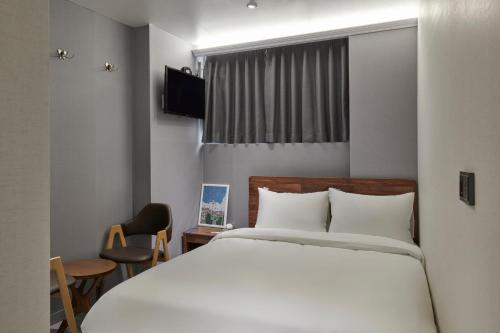 a bedroom with a white bed and a window at Eight Rest Hostel Jong-ro in Seoul