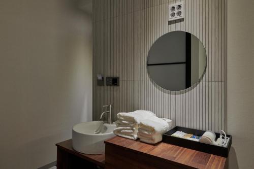 ソウルにあるEight Rest Hostel Jong-roの洗面台と鏡のあるバスルーム