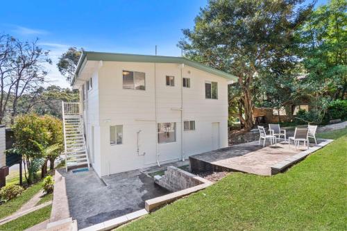 a small white house with a patio and grass at The Loft at Long Beach in Long Beach