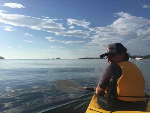 a woman is paddling a kayak in the water at The Loft at Long Beach in Long Beach