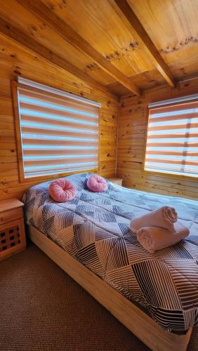 ein Schlafzimmer mit einem Bett in einer Holzhütte in der Unterkunft Cabaña kiro in Dalcahue