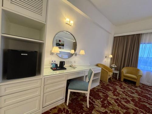 a hotel room with a desk and a flat screen tv at ROYAL PARK HOTEL @ UNITEN in Kajang