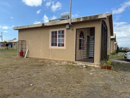 a small building with a window and a fence at Finest Accommodation Phoenix Prk Village 1,Phase 4 lot 1347, 26 Sheawater Ave in Portmore