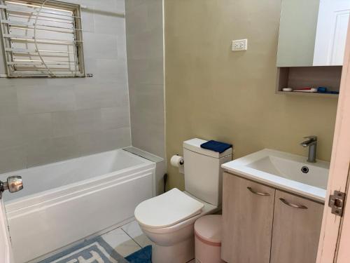 a bathroom with a toilet and a tub and a sink at Finest Accommodation Phoenix Prk Village 1,Phase 4 lot 1347, 26 Sheawater Ave in Portmore