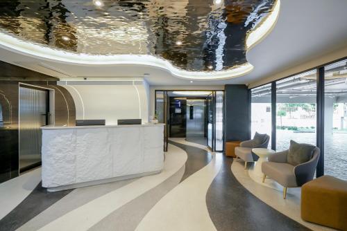 an office lobby with a reception desk and chairs at P-Park Hotel Pattaya in Pattaya North