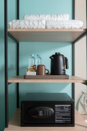 a microwave oven sitting on a shelf with a microwave at P-Park Hotel Pattaya in Pattaya North