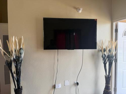a flat screen tv hanging on a wall at Finest Accommodation Phoenix Prk Village 1,Phase 4 lot 1347, 26 Sheawater Ave in Portmore