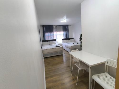 4 pers studio style room Near South Wimledon station R3 في لندن: غرفة معيشة بها طاولة وأريكة