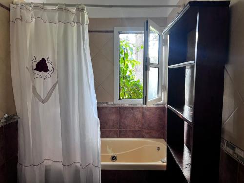 a bathroom with a tub and a shower curtain at CHALET GRANDE en VALERIA DEL MAR y PLAYA in Valeria del Mar