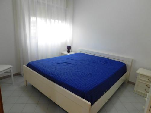 a bedroom with a blue bed with a window at Appartamento presso Residence Erice Beach - Casa Vacanza in Erice