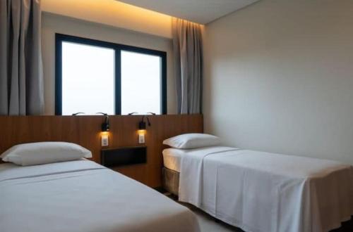 een hotelkamer met twee bedden en een raam bij Salinas Premium Resort Varanda in Salinópolis