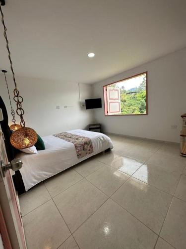 a bedroom with a bed and a window on the wall at Mahalo Hostel in Salento