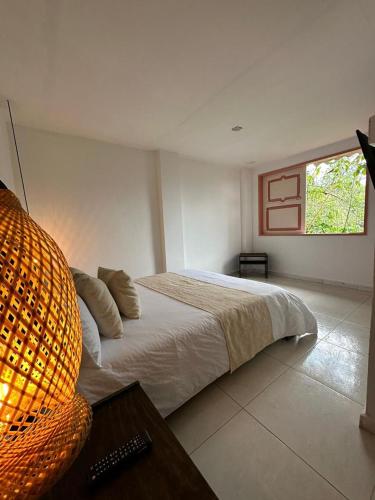 a bedroom with a large bed and a window at Mahalo Hostel in Salento