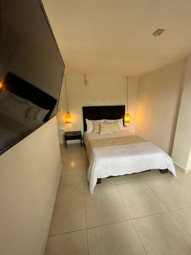 a bedroom with a large white bed and two lamps at Mahalo Hostel in Salento