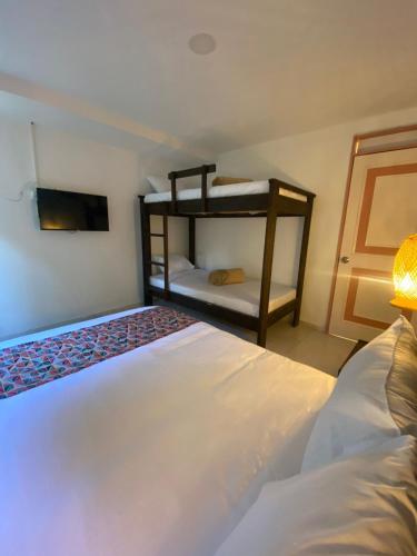 a bedroom with two beds and a bunk bed at Mahalo Hostel in Salento