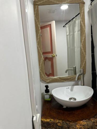 a bathroom with a white sink and a mirror at Mahalo Hostel in Salento