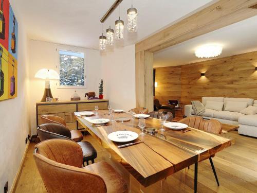 une salle à manger avec une grande table et des chaises en bois dans l'établissement Appartement de luxe 3 chambres en suite, skis aux pieds, WiFi, parking, à Courchevel 1850 - FR-1-575-237, à Courchevel