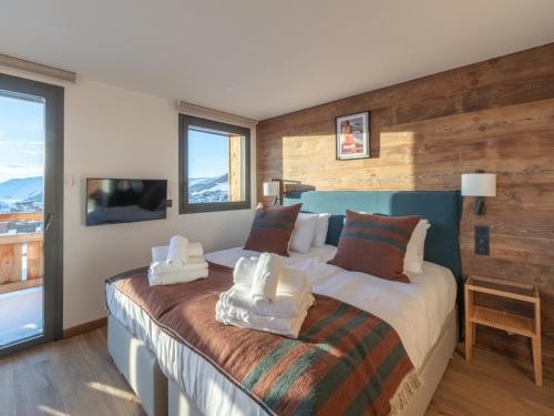 a bedroom with a bed with towels on it at Chalet d'exception, ski-in/ski-out, sauna et jacuzzi, Alpe d'Huez - FR-1-645-81 in LʼHuez