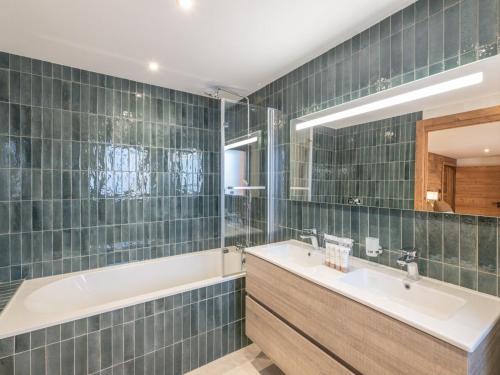 a bathroom with a tub and a sink and a bath tubermottermott at Chalet d'exception, ski-in/ski-out, sauna et jacuzzi, Alpe d'Huez - FR-1-645-81 in LʼHuez