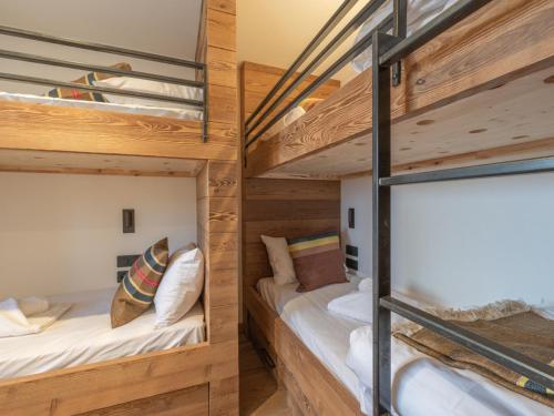 two bunk beds in a room with wooden walls at Chalet d'exception, ski-in/ski-out, sauna et jacuzzi, Alpe d'Huez - FR-1-645-81 in LʼHuez