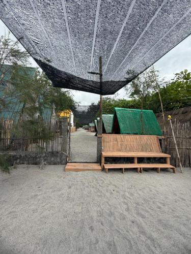 a couple of benches sitting under an umbrella at Sand Castles Beachfront Resort in Zambales