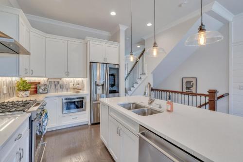 a kitchen with white cabinets and a sink at Waterside Retreat, Steps to River Street in Savannah