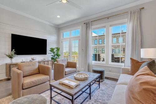 a living room with a couch and a tv at Waterside Retreat, Steps to River Street in Savannah