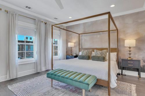 a bedroom with a canopy bed and a green bench at Waterside Retreat, Steps to River Street in Savannah