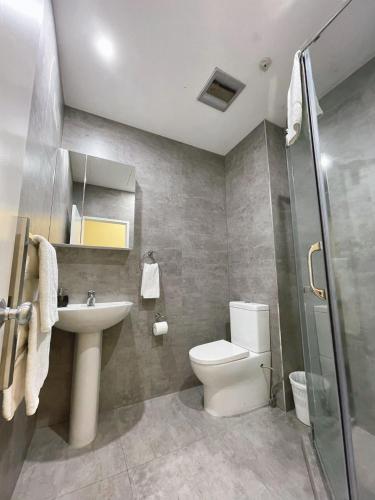 a bathroom with a toilet and a sink and a shower at Grand Central Serviced Apartments in Auckland