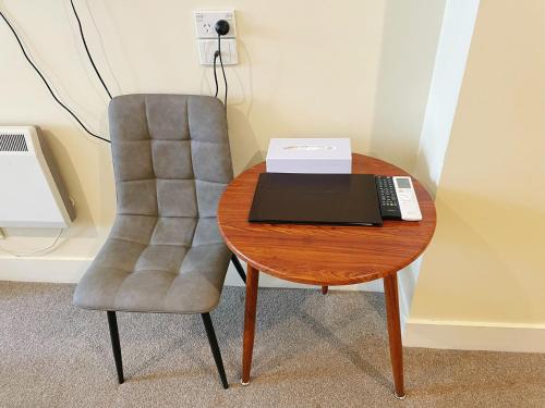 a desk with a chair and a laptop on a table at Grand Central Serviced Apartments in Auckland