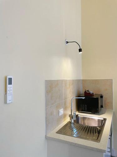 a kitchen with a sink and a microwave at Grand Central Serviced Apartments in Auckland