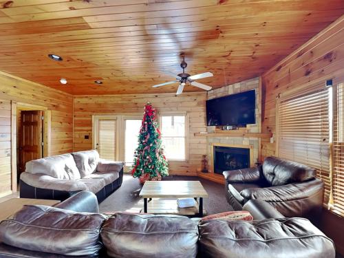 a living room with leather furniture and a christmas tree at The Great Escape II, 5 Bedrooms, Sleeps 17, Game Room, Pool Access, Theater in Gatlinburg