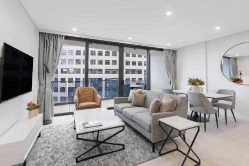 a living room with a couch and a table at Meriton Suites Canberra in Canberra