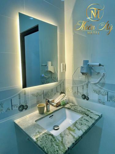 a bathroom with a sink and a mirror at Khách Sạn Thiên Mỹ in Rach Gia