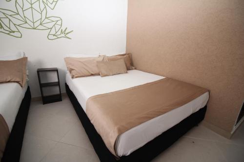 a small bedroom with two beds in it at DAM Hotel Pereira in Pereira
