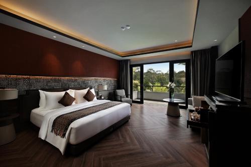 a bedroom with a large bed and a large window at Ayatara Resort Ubud in Payangan