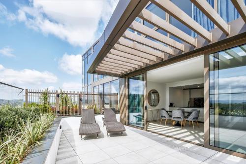 an outdoor patio with chairs and tables on a building at Meriton Suites Canberra in Canberra