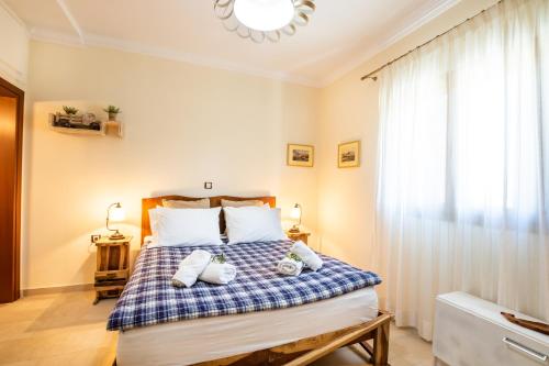 a bedroom with a bed with a blue and white comforter at Olive Studios Karpathos Studio #4 in Karpathos Town