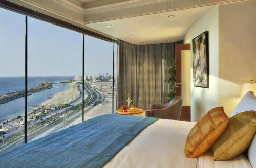 pokój hotelowy z dużym łóżkiem i dużym oknem w obiekcie Rosewood Jeddah w mieście Dżudda