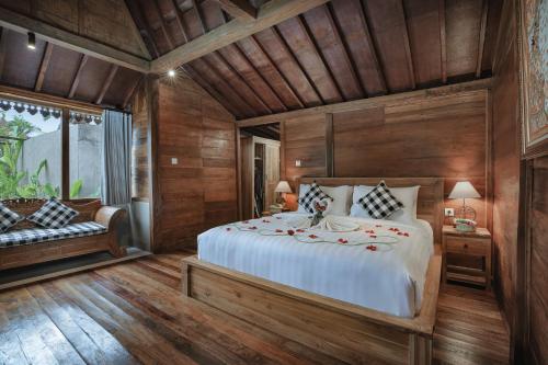 a bedroom with a large bed in a room with wooden walls at Lawani Resort in Tegalalang