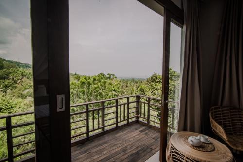 a room with a balcony with a view at Abinawa Hill in Lovina