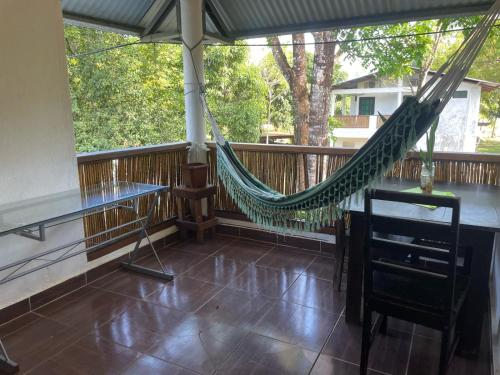 a hammock on a screened in porch with a table at Hibiscus Garden in Santa Catalina
