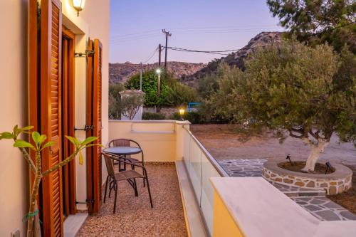 a balcony with a table and chairs and a tree at Olive Studios Karpathos Studio #4 in Karpathos Town