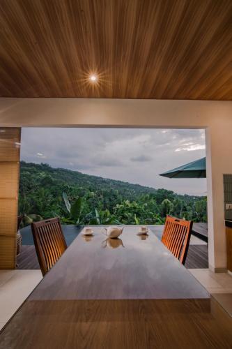 a dining room with a table with chairs and a view at Abinawa Hill in Lovina