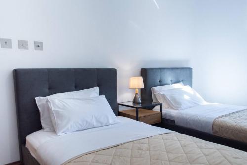 a bedroom with two beds and a lamp on a table at Aphrodite Premium Apartments I in Kouklia