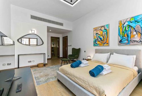 a bedroom with a large bed with blue pillows on it at Aphrodite Premium Apartments I in Kouklia
