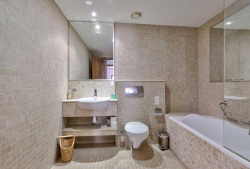 a bathroom with a toilet and a sink and a tub at Aphrodite Premium Apartments I in Kouklia