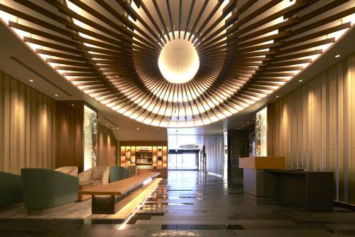 a lobby with a large ceiling with a large chandelier at Hotel Metropolitan Akita in Akita